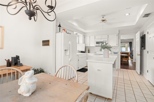 dining room featuring light tile patterned floors, visible vents, a tray ceiling, and ceiling fan