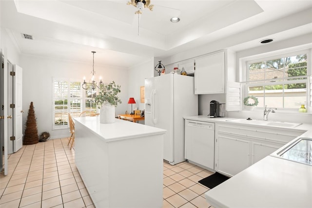 kitchen with white appliances, light tile patterned floors, visible vents, a raised ceiling, and a sink