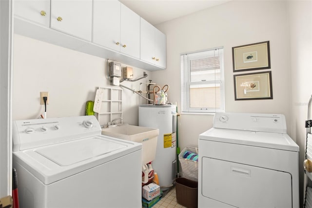 washroom with water heater, washer and clothes dryer, and cabinet space