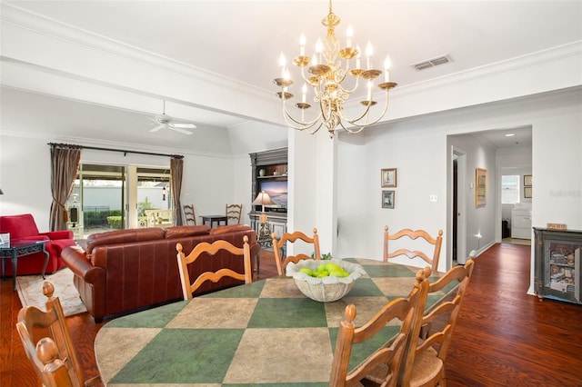 dining room featuring crown molding, visible vents, wood finished floors, and ceiling fan with notable chandelier