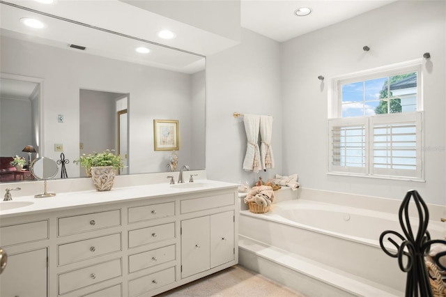 bathroom featuring double vanity, a garden tub, a sink, and recessed lighting