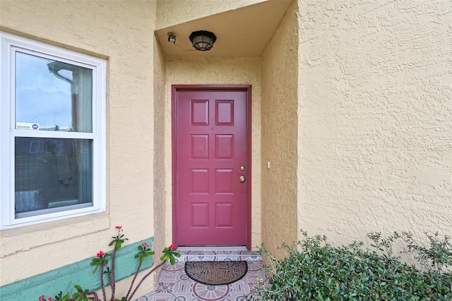 view of exterior entry featuring stucco siding