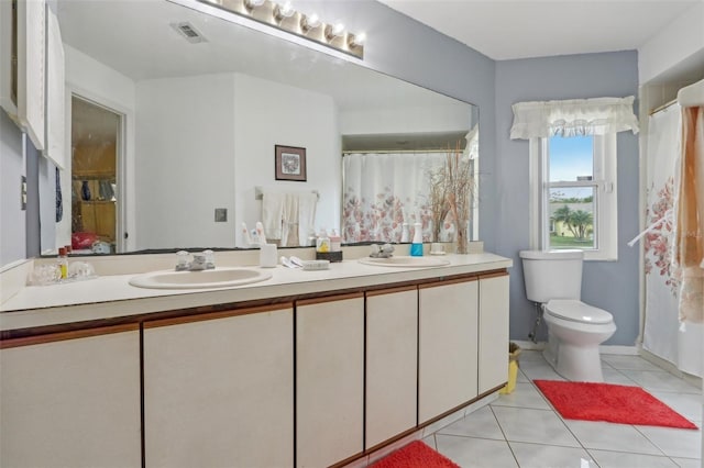 full bath with tile patterned flooring, visible vents, double vanity, and a sink