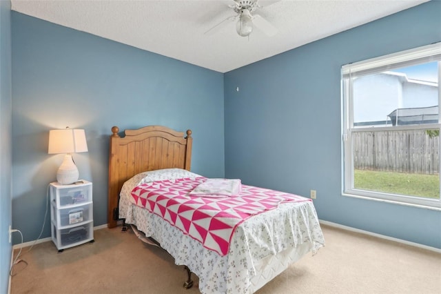 carpeted bedroom with multiple windows, a ceiling fan, and baseboards