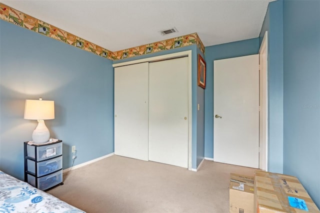 unfurnished bedroom with a closet, visible vents, baseboards, and carpet floors