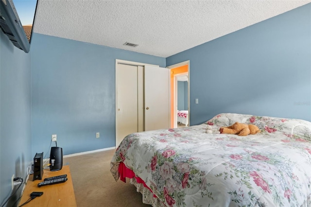 carpeted bedroom featuring a closet, baseboards, a textured ceiling, and visible vents