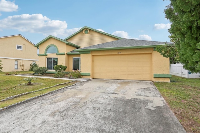 single story home with stucco siding, fence, concrete driveway, an attached garage, and a front yard