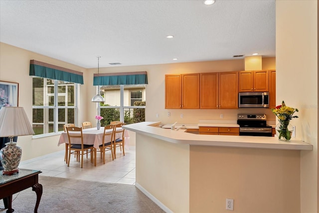 8606 Terrace Pines Ct, Orlando, FL 32836 - kitchen featuring appliances with stainless steel finishes, light countertops, light tile patterned flooring, and a peninsula