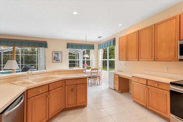 8606 Terrace Pines Ct, Orlando, FL 32836 - kitchen with appliances with stainless steel finishes, light countertops, a sink, and built in desk