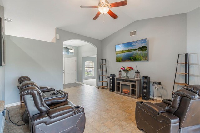 2851 Stonewood Cir, Lakeland, FL 33810 - living room featuring arched walkways, a warm lit fireplace, ceiling fan, visible vents, and vaulted ceiling
