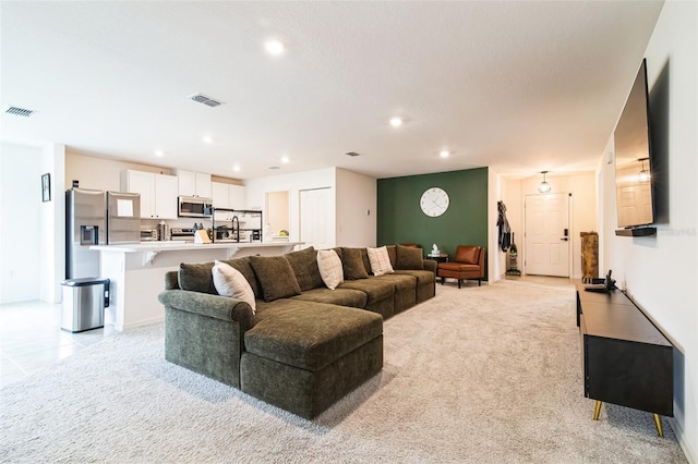 living room with light carpet, light tile patterned floors, visible vents, and recessed lighting