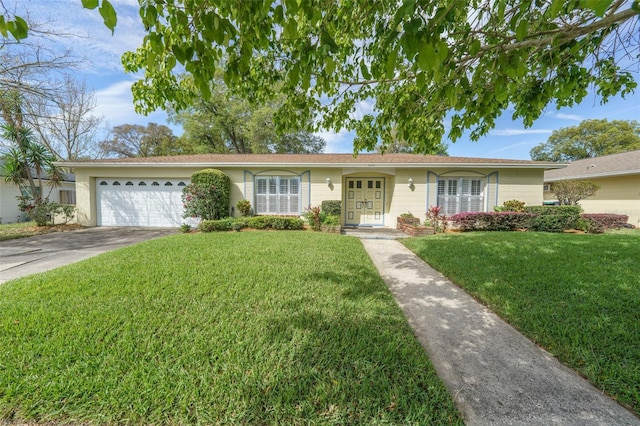 ranch-style home featuring driveway, an attached garage, and a front yard