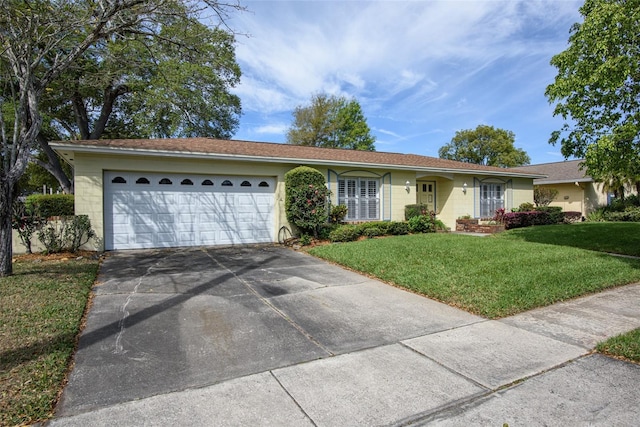 ranch-style house featuring a front lawn, concrete driveway, and an attached garage