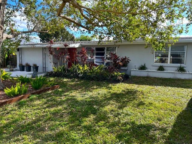 ranch-style home featuring stucco siding and a front yard