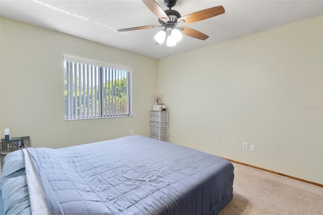 carpeted bedroom featuring a textured ceiling, a ceiling fan, and baseboards