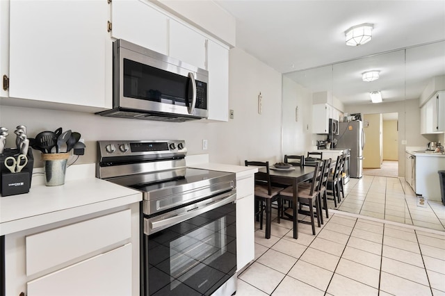 kitchen featuring light countertops, appliances with stainless steel finishes, light tile patterned flooring, and white cabinetry