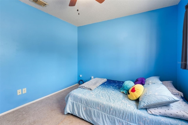 bedroom with carpet floors, visible vents, a ceiling fan, a textured ceiling, and baseboards