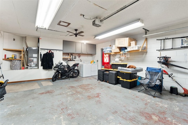 garage with a garage door opener, concrete block wall, and washer and dryer