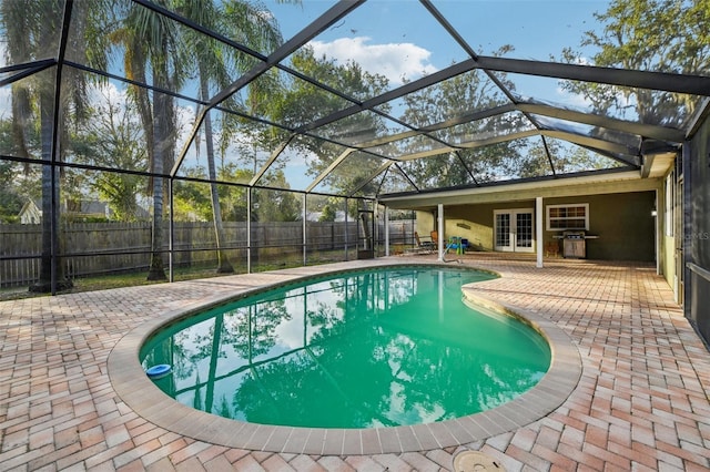 view of pool featuring french doors, a patio, a grill, and a fenced backyard