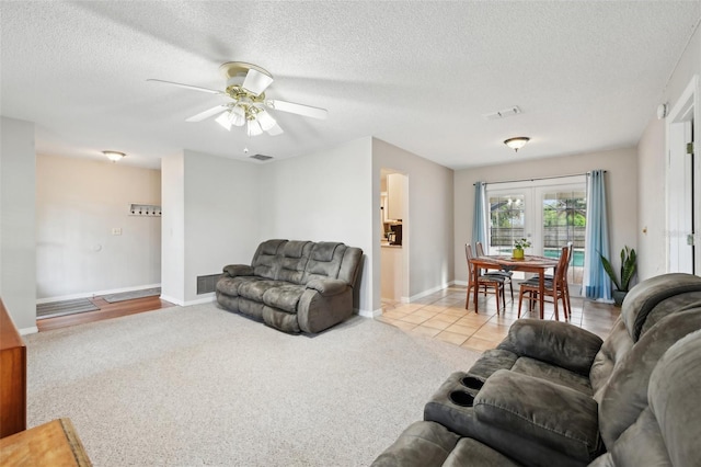 carpeted living area with baseboards, visible vents, and a textured ceiling