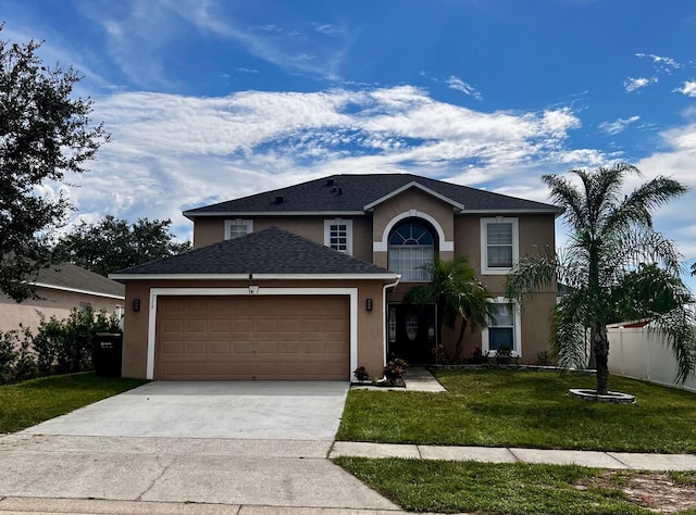 traditional-style home with a front lawn, concrete driveway, an attached garage, and stucco siding