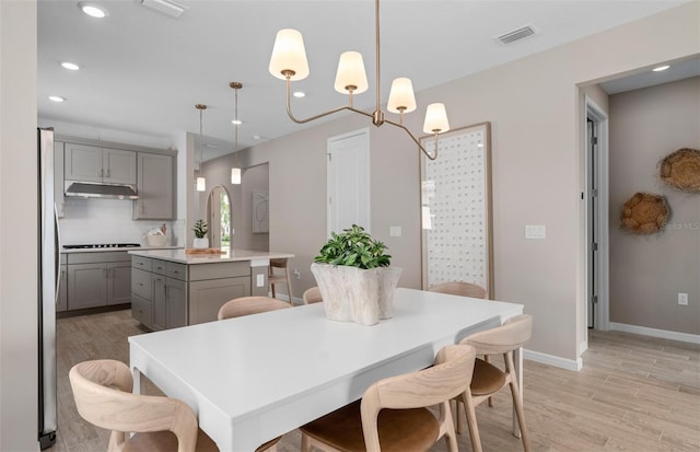 dining space featuring baseboards, visible vents, light wood-style flooring, and recessed lighting