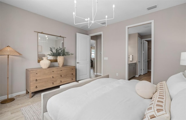 bedroom featuring baseboards, visible vents, ensuite bath, wood finished floors, and an inviting chandelier