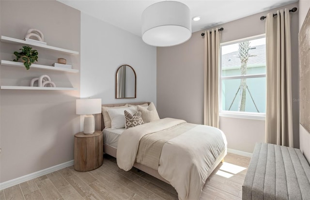 bedroom with baseboards and wood finished floors