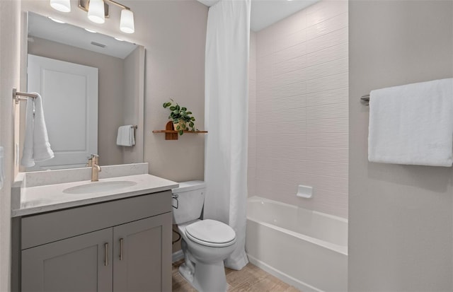 bathroom with toilet, wood finished floors, visible vents, vanity, and shower / tub combo with curtain