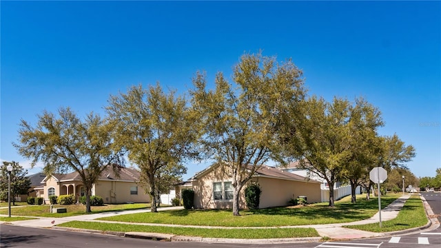 view of front facade featuring a front yard and stucco siding