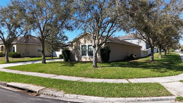 view of front of house with stucco siding and a front lawn