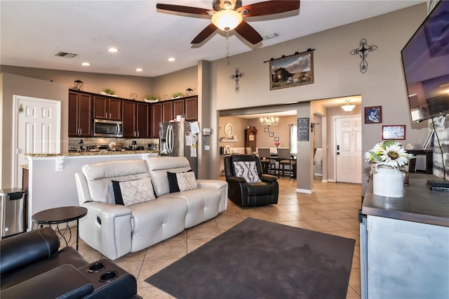 living area with light tile patterned floors, a ceiling fan, and visible vents