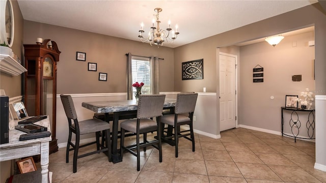 dining space with light tile patterned floors, an inviting chandelier, and baseboards