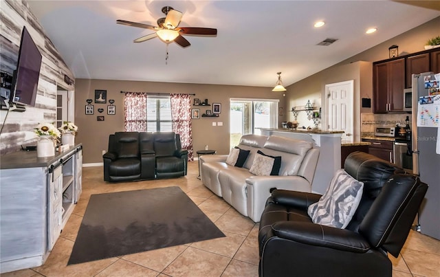 living room with vaulted ceiling, light tile patterned flooring, visible vents, and ceiling fan