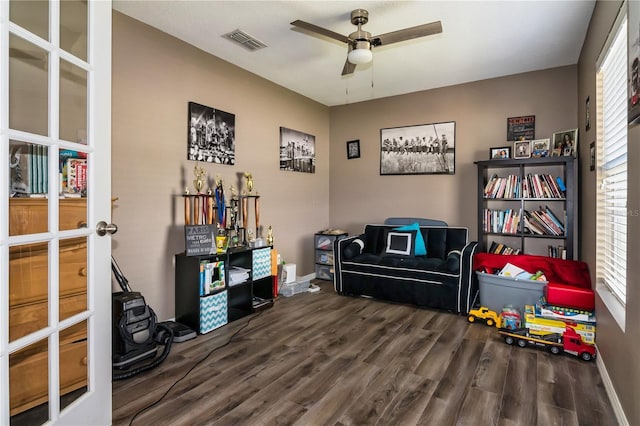 recreation room featuring dark wood-style floors, a ceiling fan, visible vents, and a wealth of natural light