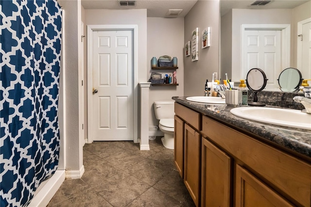 full bath featuring a sink, visible vents, toilet, and double vanity