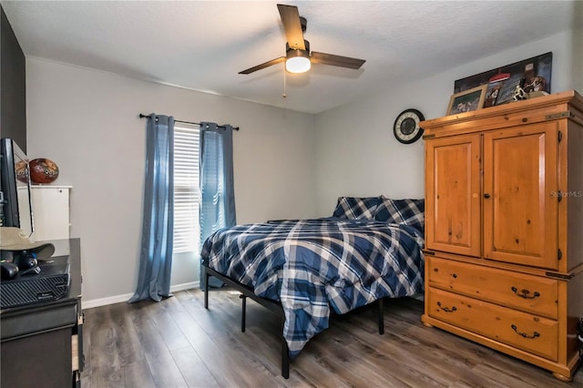 bedroom featuring baseboards, dark wood-type flooring, and ceiling fan