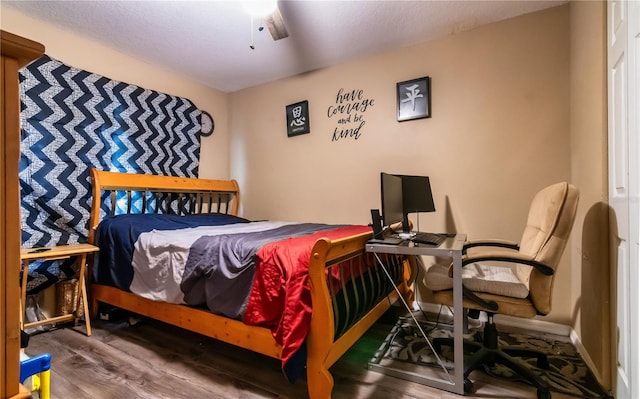 bedroom with ceiling fan, baseboards, and wood finished floors