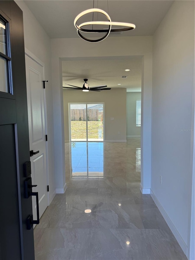 hallway featuring marble finish floor, visible vents, and baseboards