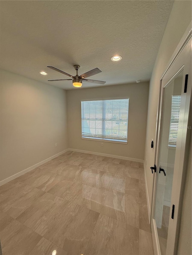 unfurnished room with a textured ceiling, baseboards, a ceiling fan, and recessed lighting