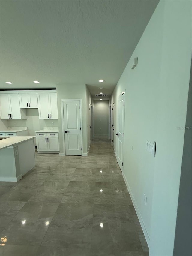 interior space with baseboards, white cabinetry, light countertops, and recessed lighting