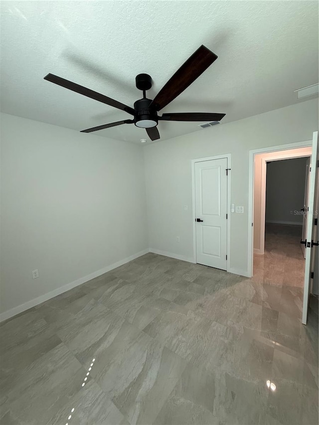 unfurnished bedroom with a ceiling fan, visible vents, baseboards, and a textured ceiling