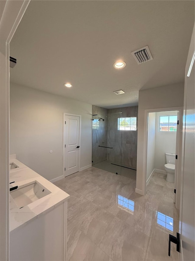 bathroom with recessed lighting, visible vents, toilet, a shower stall, and baseboards