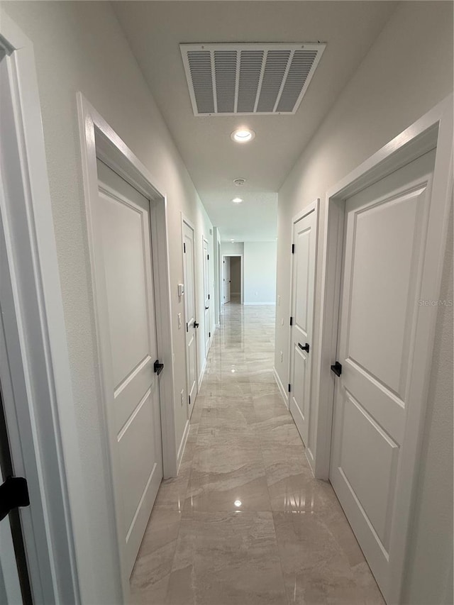 hall with marble finish floor, baseboards, visible vents, and recessed lighting