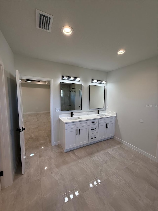 full bathroom with visible vents, a sink, a shower stall, and double vanity