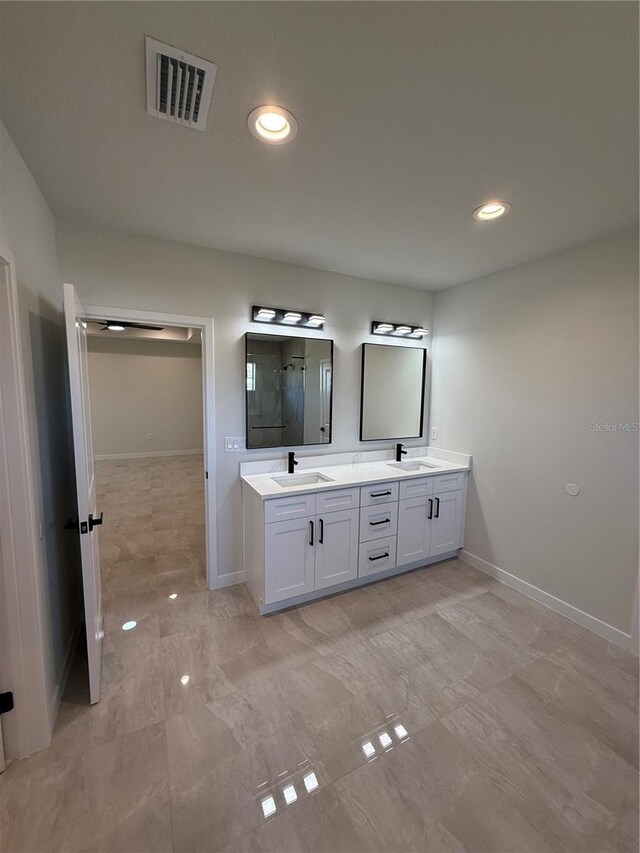 bathroom with a stall shower, visible vents, a sink, and double vanity