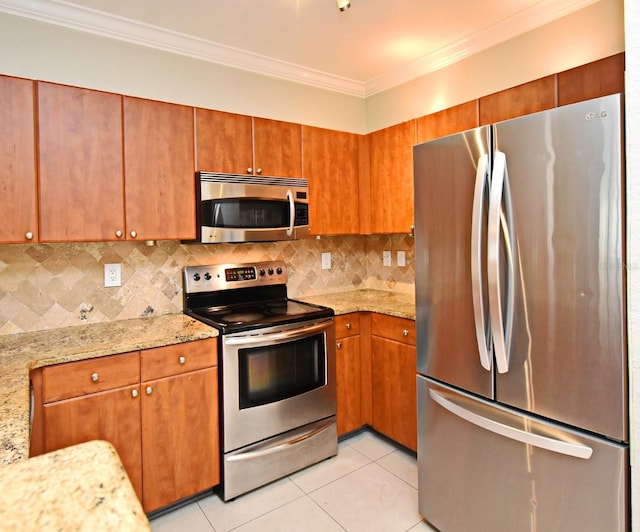 kitchen with ornamental molding, appliances with stainless steel finishes, brown cabinetry, and decorative backsplash