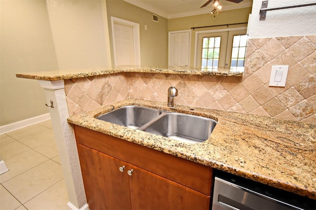 kitchen with a sink, backsplash, light stone countertops, dishwasher, and crown molding