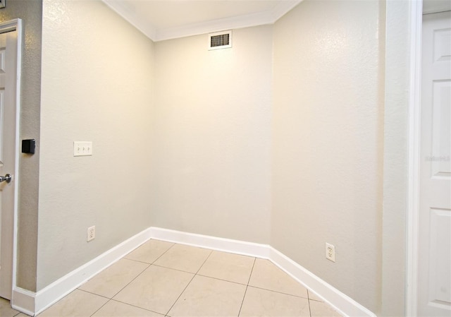 laundry area featuring baseboards, visible vents, crown molding, and light tile patterned flooring