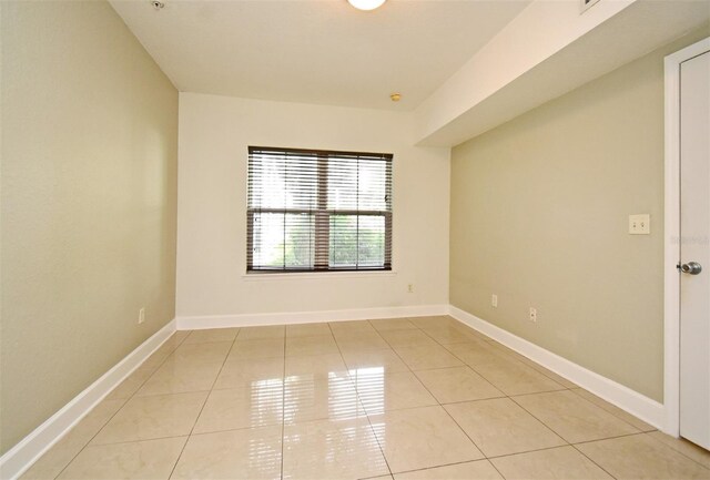 spare room with light tile patterned floors and baseboards